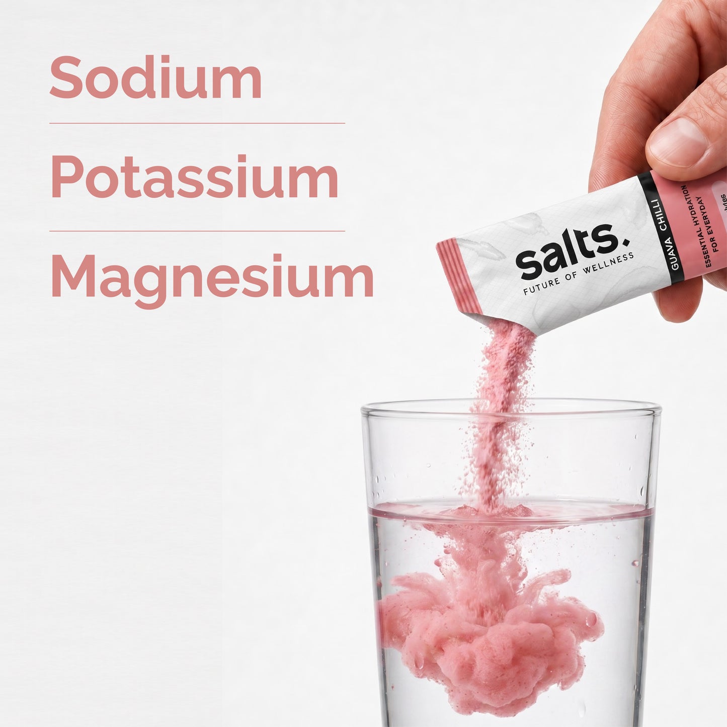 Salts powder is being poured from Guava Chilli flavour packet into a clear glass of water, with the text 'Sodium Potassium Magnesium' on the left.